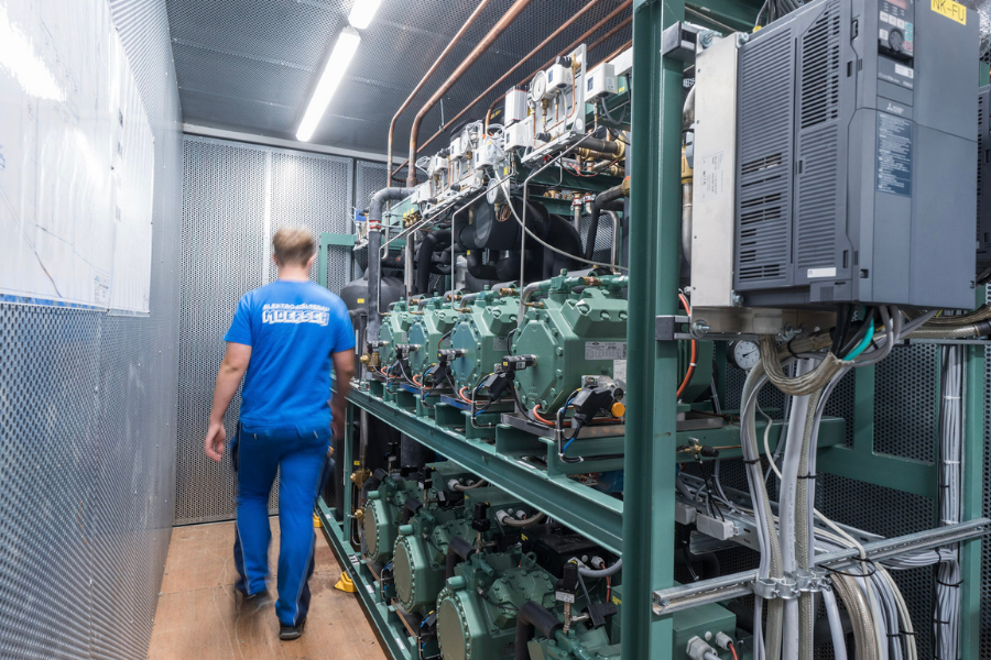 Mitarbeiter läuft an Kälteanlage vorbei