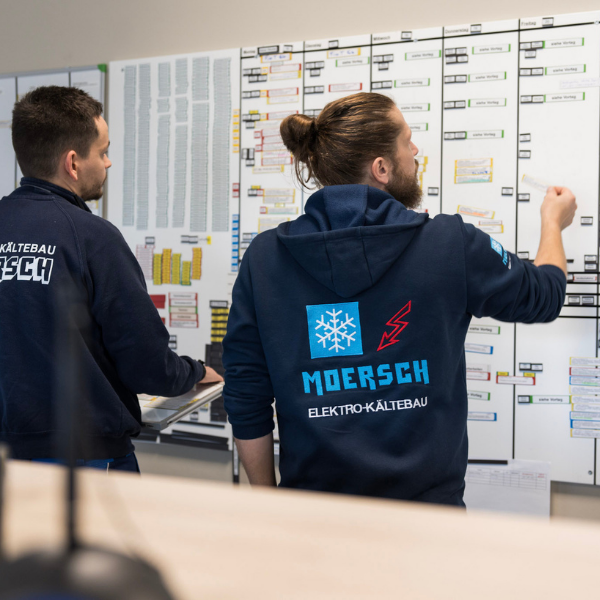 Chef und Mitarbeiter in der Projektübersicht im Büro